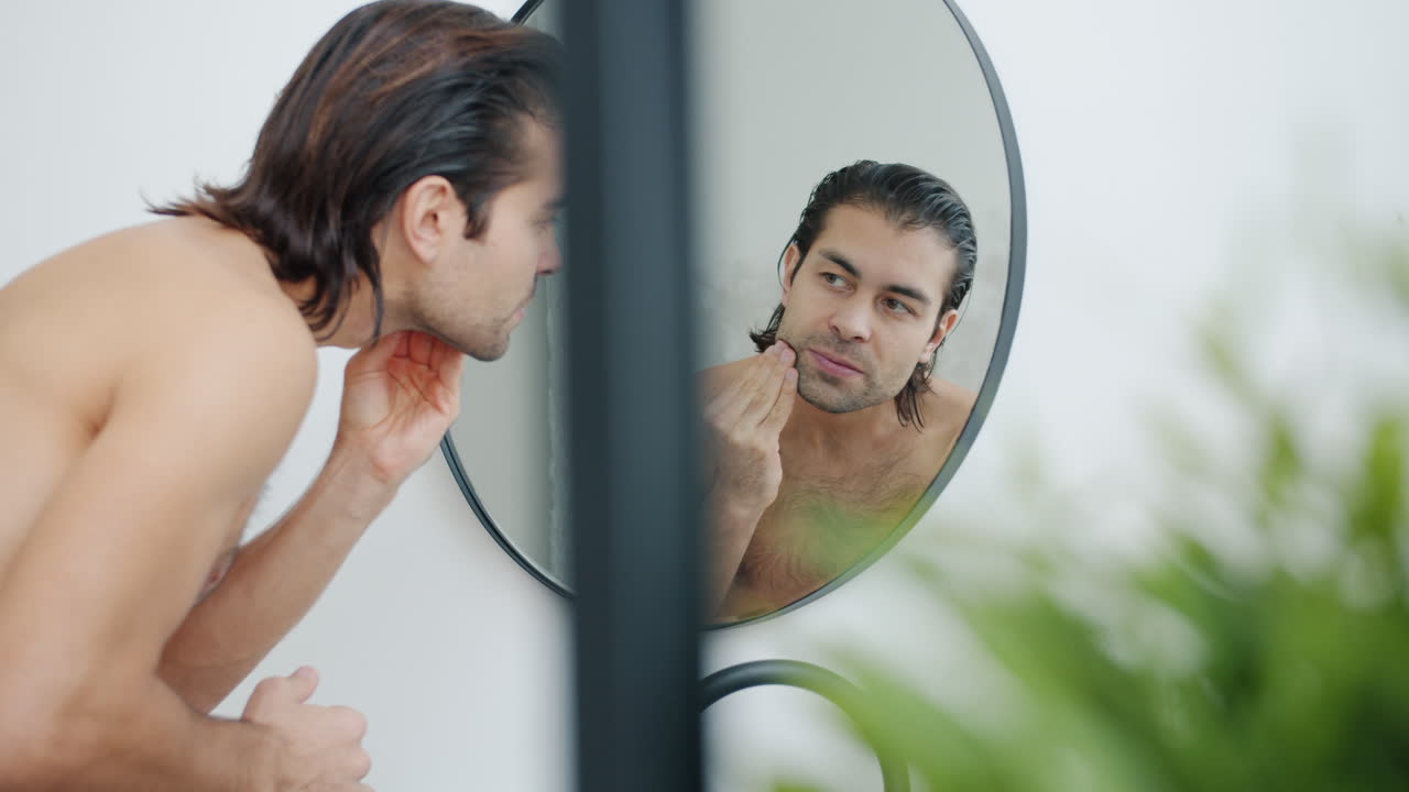 욕실 거울에서 자신의 외모를 확인하는 남자