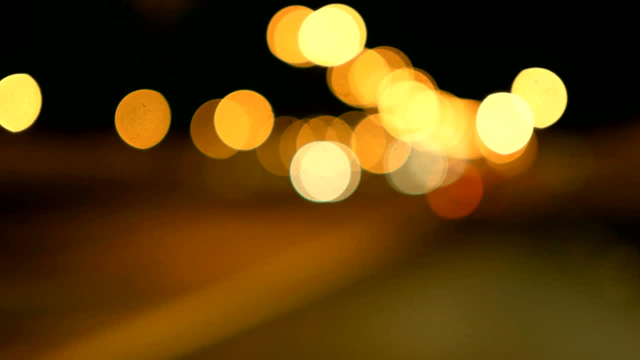 conducir un coche a través de la carretera de la noche, la autopista. luces desenfocadas calle de los ángeles resumen. ciudad fondo borroso. movimientos círculos bokeh de tráfico nocturno.