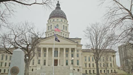 kansas state capitol building with flags waving in topeka, kansas with wide shot video in slow motion.