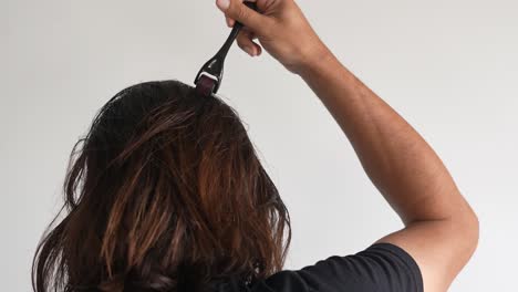 man using roller hair on his scalp to prevent baldness, hair loss