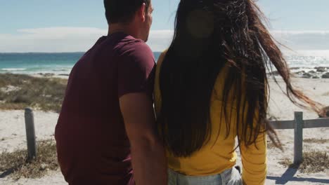 Happy-caucasian-couple-sitting-in-beach-buggy-by-the-sea-talking