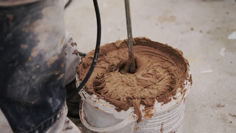 A-construction-worker-is-mixing-glue-in-a-bucket