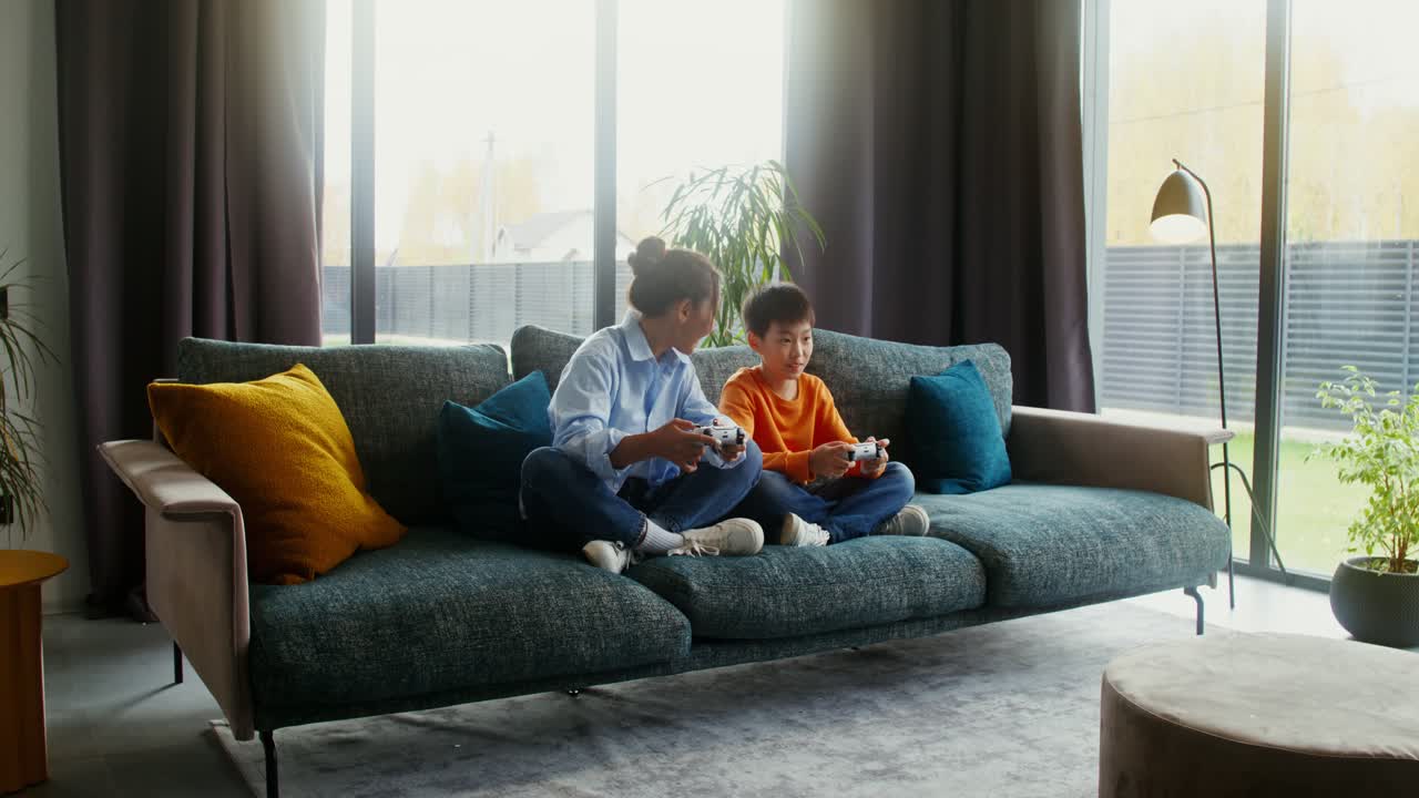 Woman and Boy Playing Video Games on Couch