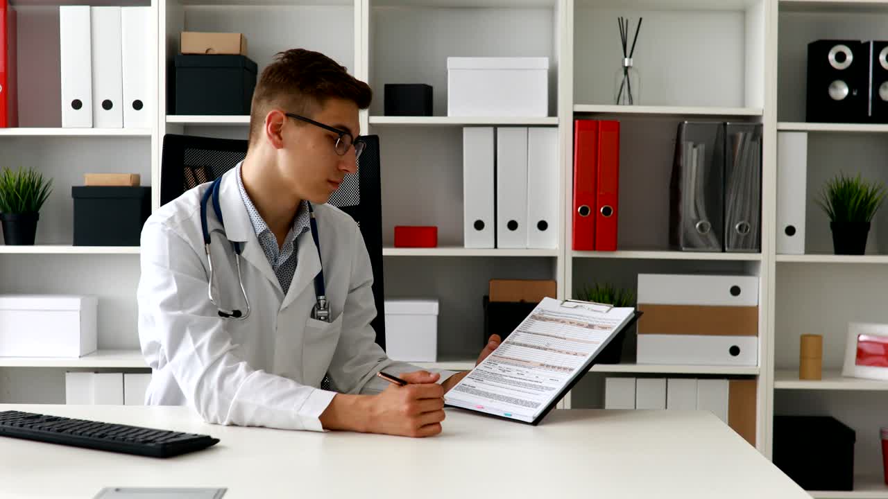 joven médico mostrando papel y mirando a la cámara