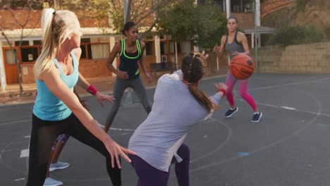 equipo de baloncesto femenino diverso jugando partido, driblando la pelota y marcando goles