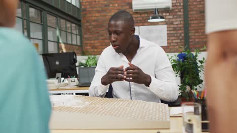 happy diverse architects looking at architectural models at office