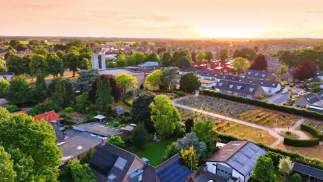 lush greenery of the town from drone footage. approaching church and cemetery in overloon, the netherlands