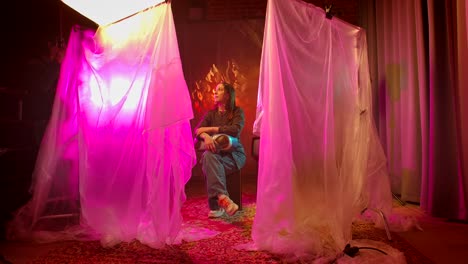 woman posing in a studio with dramatic pink lighting
