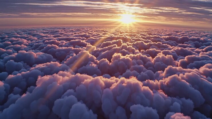 Aerial view of a stunning sunrise over fluffy clouds, casting warm hues