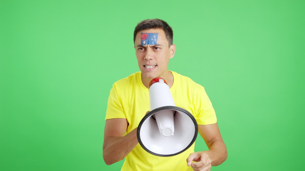 Excited man with australian flag on face using a megaphone