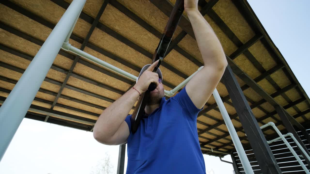 un deportista dispara con una escopeta de doble cañón, un campo deportivo para una prueba de tiro está disparando a un esquete volador