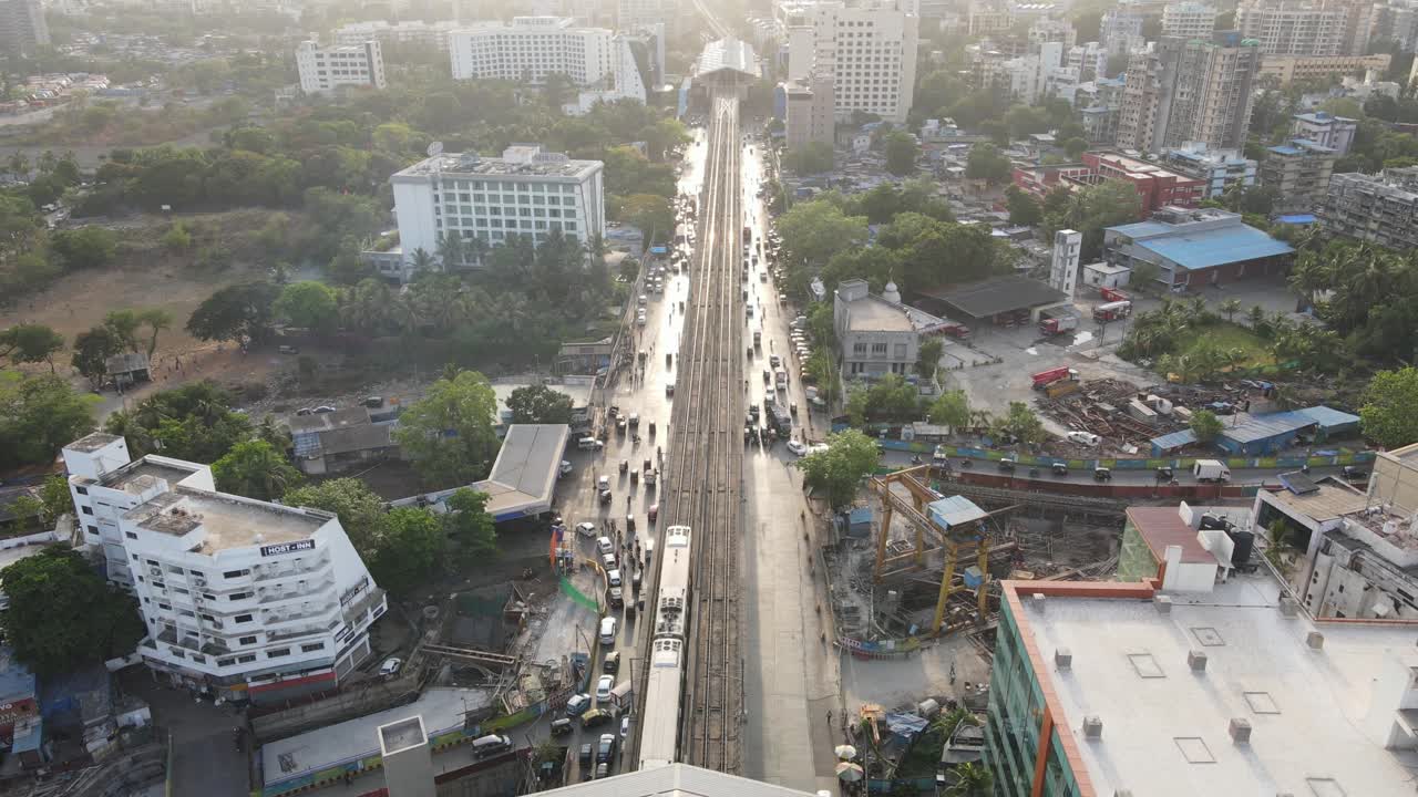 Vista a volo d'uccello da drone della stazione della metropolitana di Marol e dell'aeroporto internazionale di Mumbai, India. Treno grandangolare in partenza dalla stazione di Andheri alla stazione di Maroli.