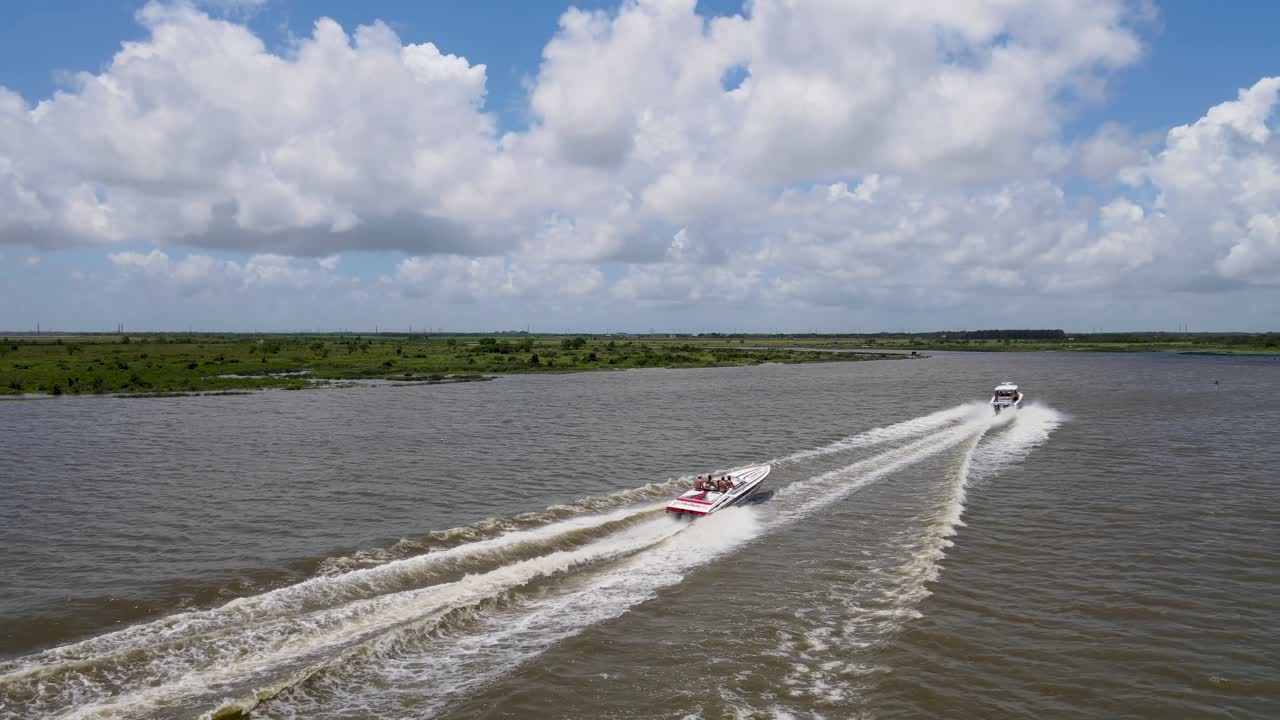 Speedboats cruising on a river under a partly cloudy sky