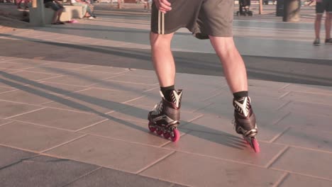 cámara lenta, primer plano en los pies de la persona patinando en el pavimento durante la hora dorada