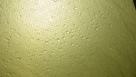 gotas de lluvia corriendo por el costado de una tienda de campaña