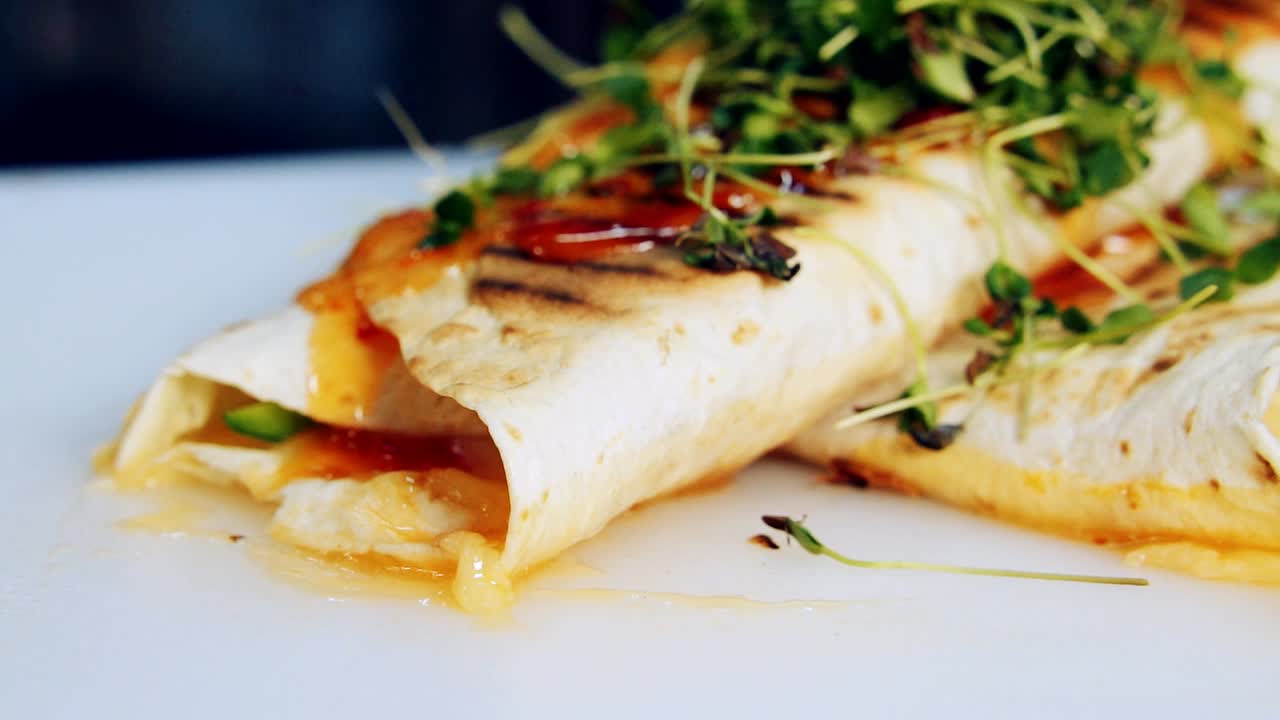 Delicious restaurant dish spinning. Grilled pita decorated with green sprouts ready to eat. Beautiful presentation of tasty appetizer. Close-up