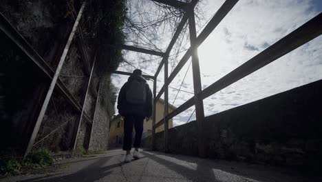 toma en cámara lenta de un joven adolescente caminando solo en la ciudad bajo un cielo azul