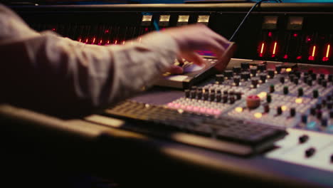 sound designer working with sliders and switchers on control desk