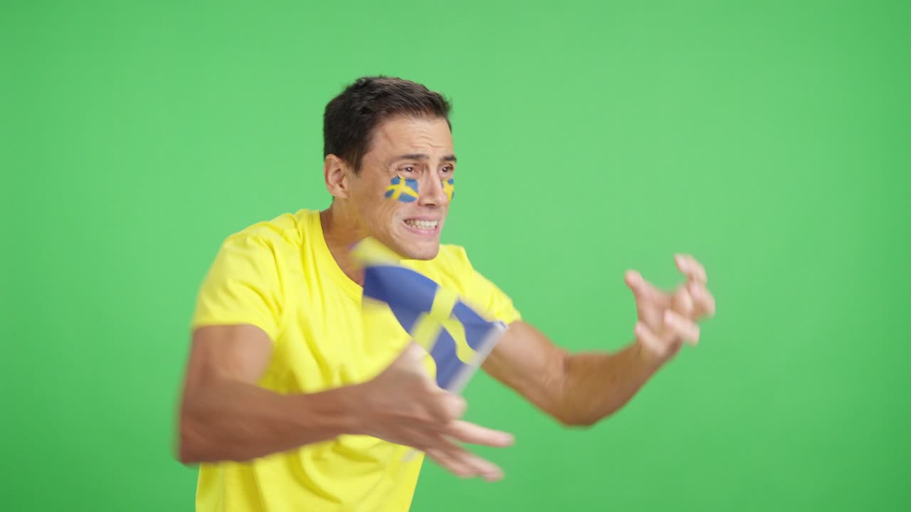 Nervous man cheering for Sweden during a match looking away