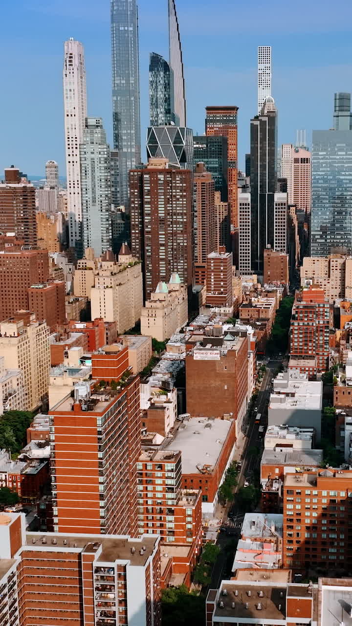 Bright sun lighting the facades of multistoried buildings and skyscrapers of New York. Metropolis cityscape from aerial perspective. Vertical video