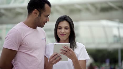 Lächelnde-Gute-Freunde-Reden,-Während-Sie-Auf-Das-Tablet-Schauen