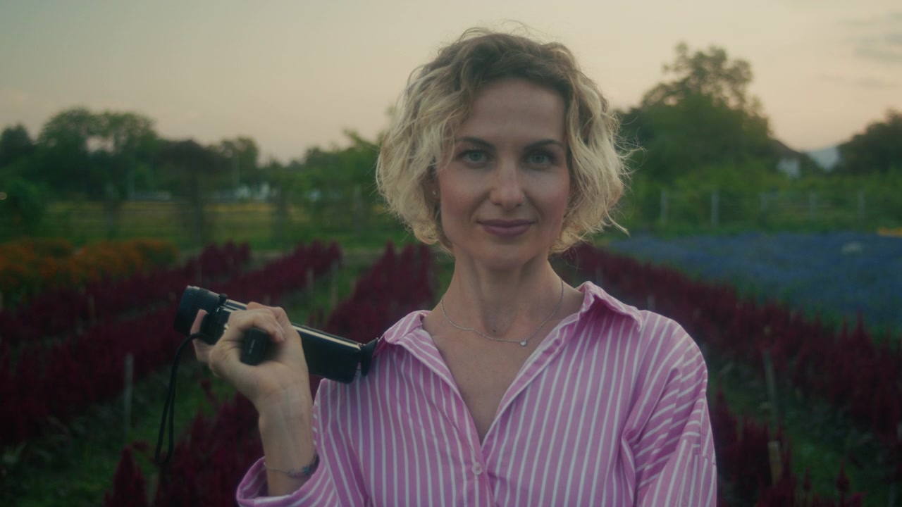 Woman Holding Vintage Super 8 Camera in Flower Field
