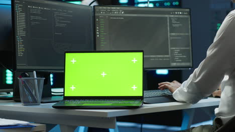 Zoom-in-on-green-screen-laptop-used-by-data-center-worker-troubleshooting-issues