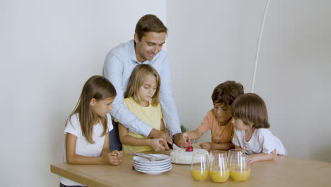 Papá-Ayudando-A-Su-Hija-Emocionada-A-Cortar-El-Pastel-Festivo