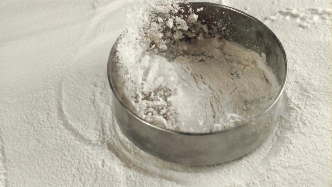 Gerakan Lambat Mengayak Tepung Putih ke dalam Cetakan Kue Logam