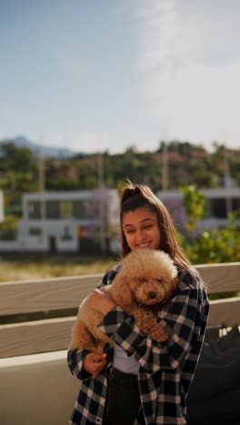 woman holding a small poodle dog outdoors