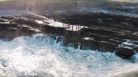 a stunning view of strong waves crashing into the rocks. this was shot in malahide during a very windy day.