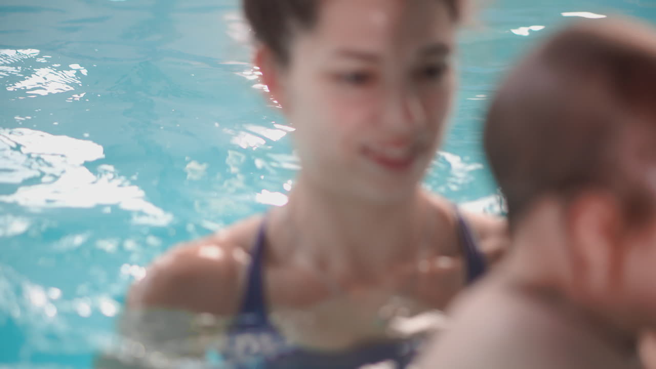 귀여운 아기가 엄마와 함께 수영장에서 즐기고 있습니다.