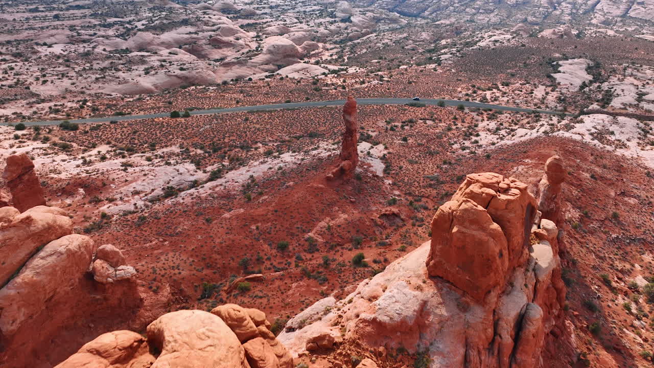 Rocce rosse fantastiche con cime arrotondate nel paesaggio desertico. Avvicinamento all'autostrada che attraversa il paesaggio dell'Arches National Park, Utah, USA