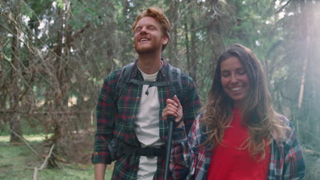 couple walking in summer woods. happy man and woman hiking in fairytale forest