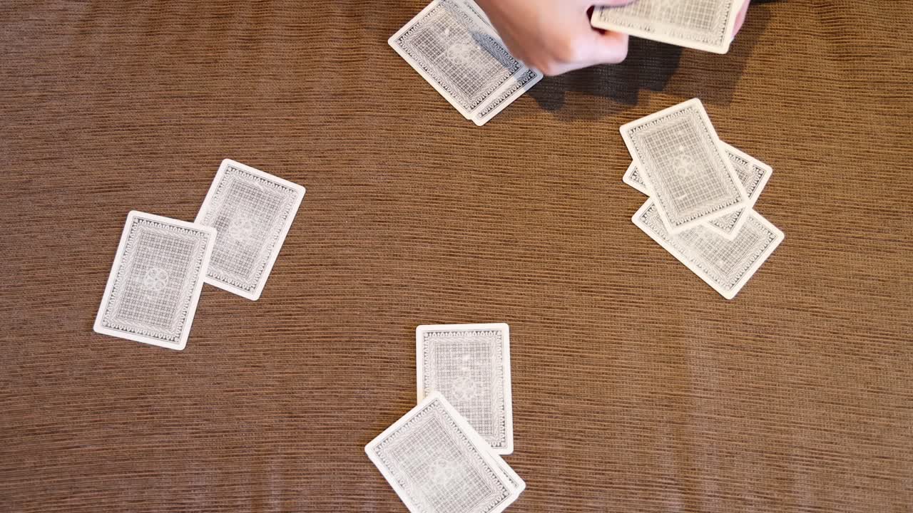 las manos habilmente mezclando cartas de juego en una mesa