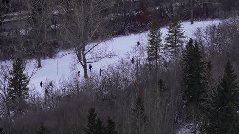 Innenstadt-Von-Edmonton-Größte-Natürliche-Eislaufbahn-Im-Freien-700-Meter-Lang-2-Kilometer-Vereiste-Wanderwege-River-Valley-Of-North-Saskatchewan-River-Victoria-Park-Familie-Schließt-Sich-Der-Hand-An,-Kleinkind-Auf-Schlittschuhschlitten-2-4