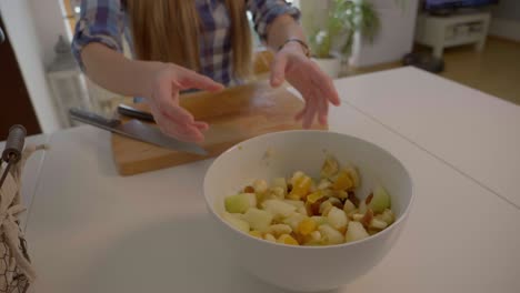 Dies-Ist-Eine-4K-Zeitlupenaufnahme-Mit-60-Bildern-Pro-Sekunde,-Die-Ein-Mädchen-Zeigt,-Das-Eine-Weiße-Schüssel-Mit-Obstsalat-Darin-Bewegt