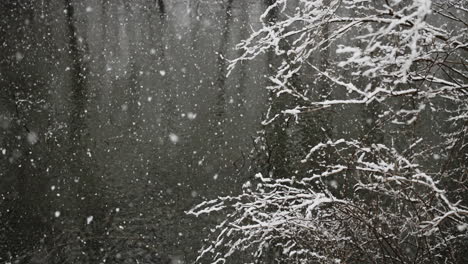 Pan-into-wintery-scene-with-snow-falling-in-river