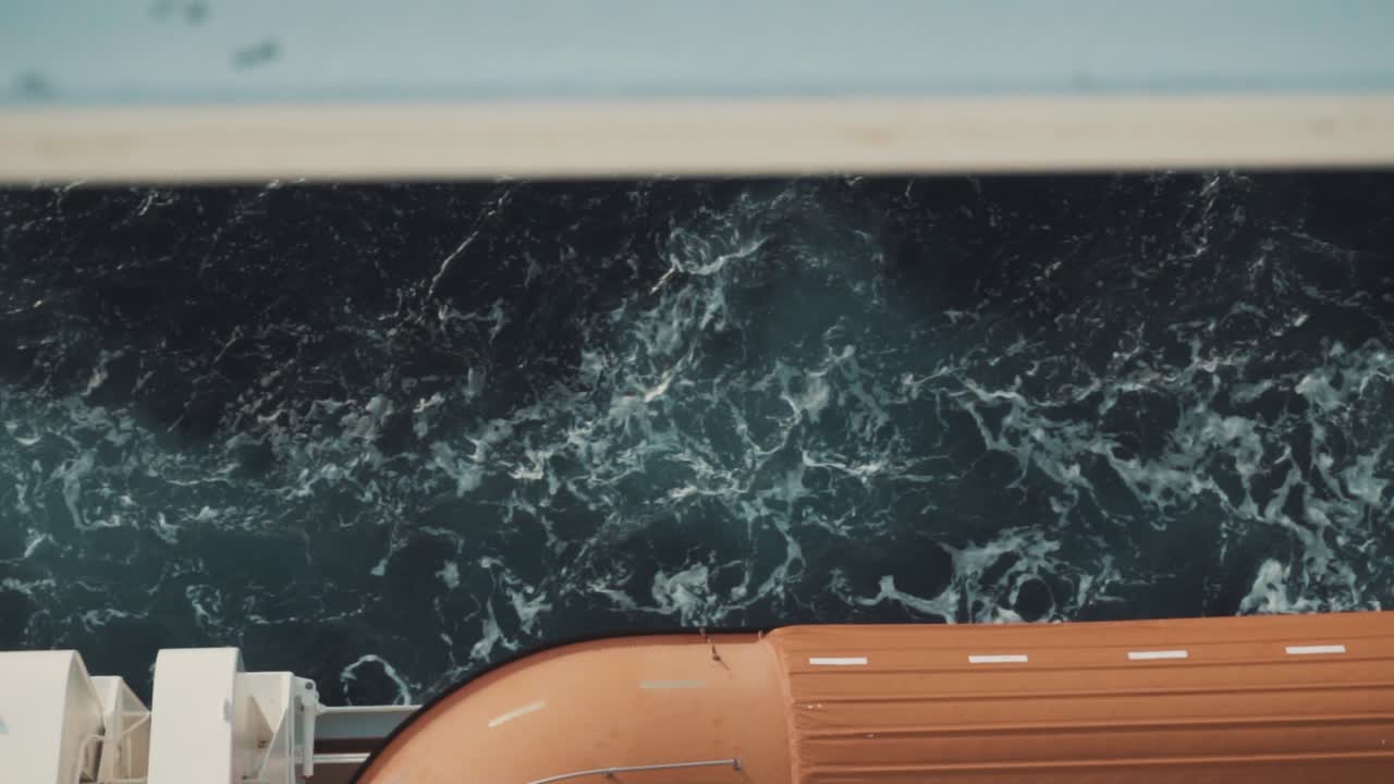 Zeitlupen-Verfolgungsaufnahme des Ozeans, der an einem großen Kreuzfahrtschiff vorbeirauscht