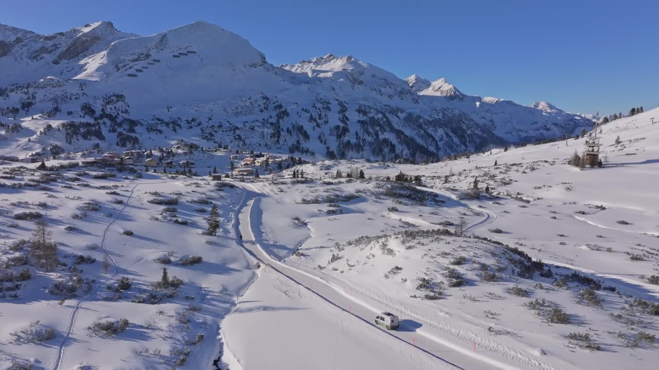 Aerial view of a camper navigating a snowy road through Obertauern village