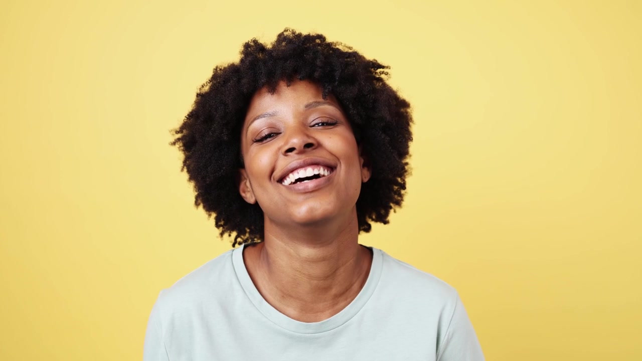 Cheerful African American Woman with Curly Hair Smiling and Laughing
