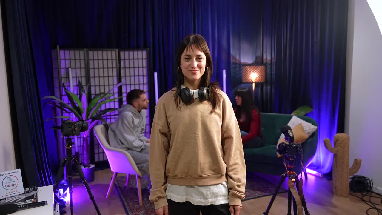 Giovane donna si mette le cuffie e sorride in studio