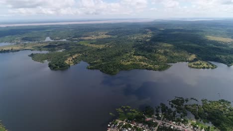 Drohne-Erfasst-Den-Fluss-Des-Amazonas,-Der-In-Der-Nähe-Der-Stadt-Parintins,-Brasi-Und-Der-Stadt-Fließt,-Die-Am-Rand-Angesiedelt-Ist