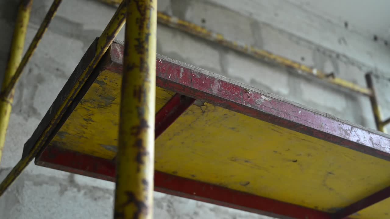 Dirty red and yellow scaffold in a construction interior