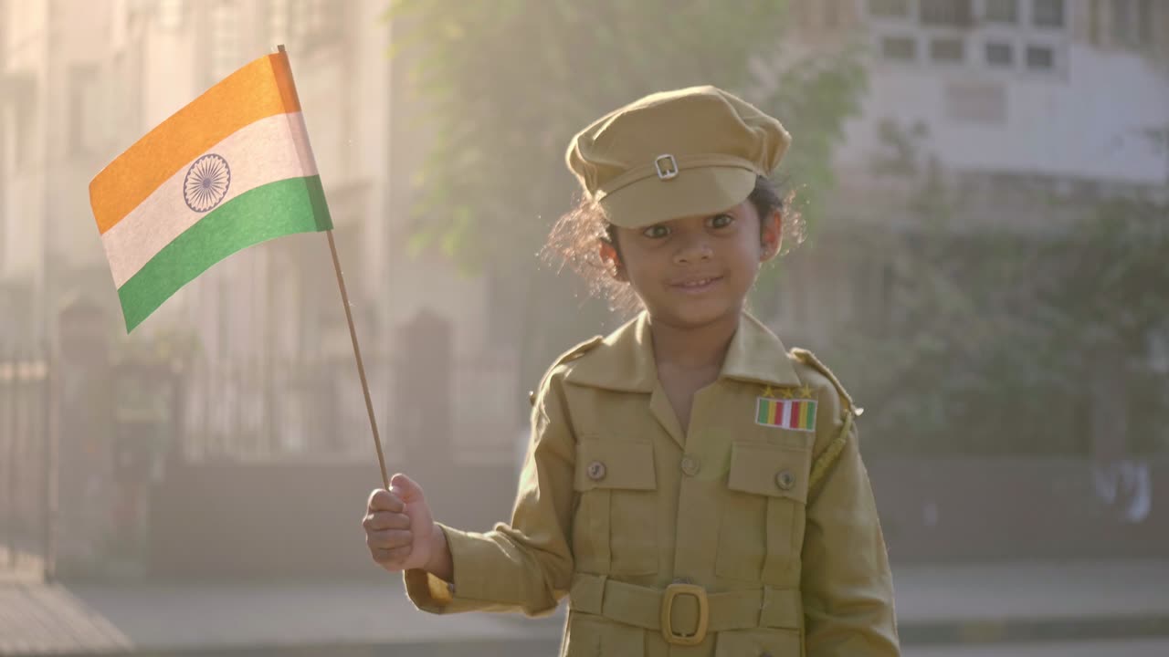 Uma jovem sorridente, feliz e fofa vestindo uniforme de soldado e segurando uma bandeira nacional indiana, tricolor, na mão.