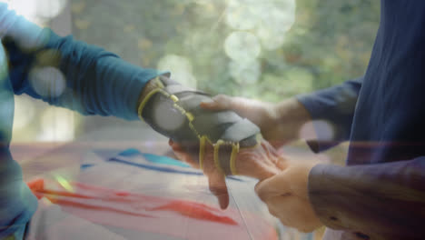 spots of light against mid section of man putting hand strap on womans hand