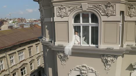 bride posing in window of building