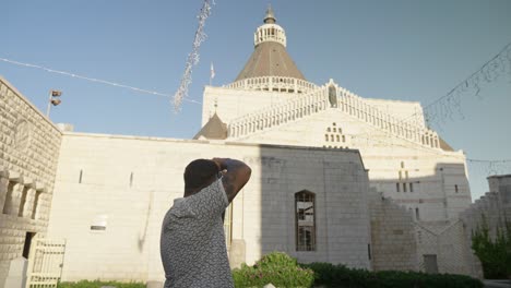 Male-photographer-photographs-facade-of-Annunciation-Church,-Nazareth