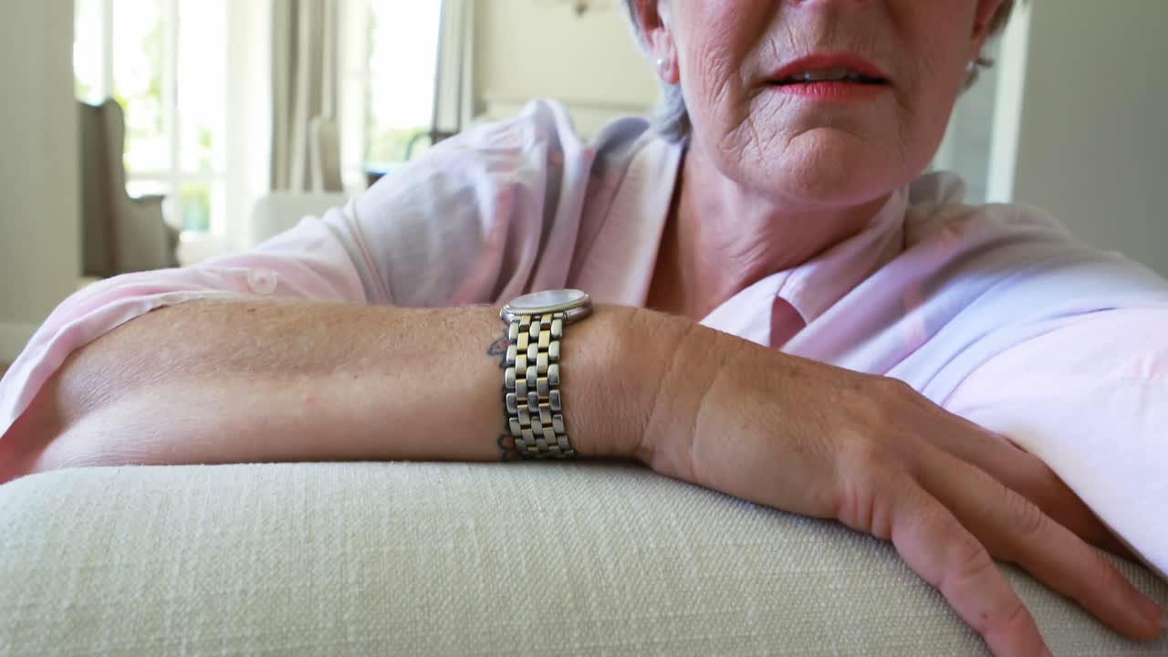 거실의 소파에 앉아 있는 미소 짓는 고령 여성의 초상화