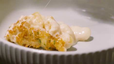 macaroni cheese after being placed in bowl with crispy bread crumb coating. pasta based dinner food meal footage